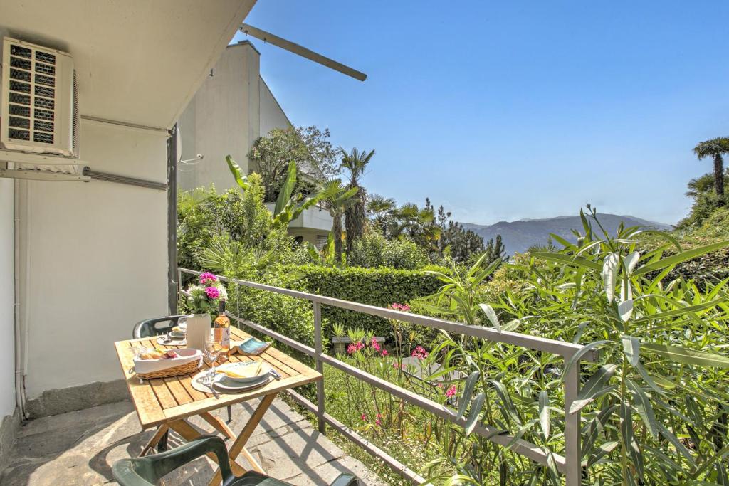 a table on the balcony of a house at Studio w/Panoramic view, Shared Pool, Garden & Terrace - Happy Rentals in Agno