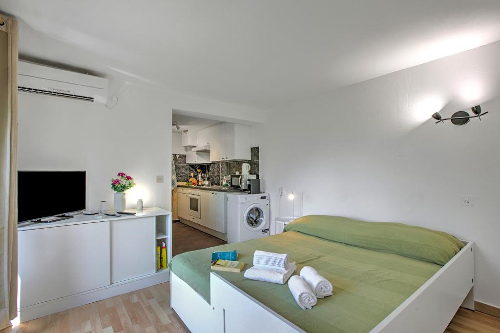 a white bedroom with a bed and a kitchen at Apartment View And Pool - Happy Rentals in Agno