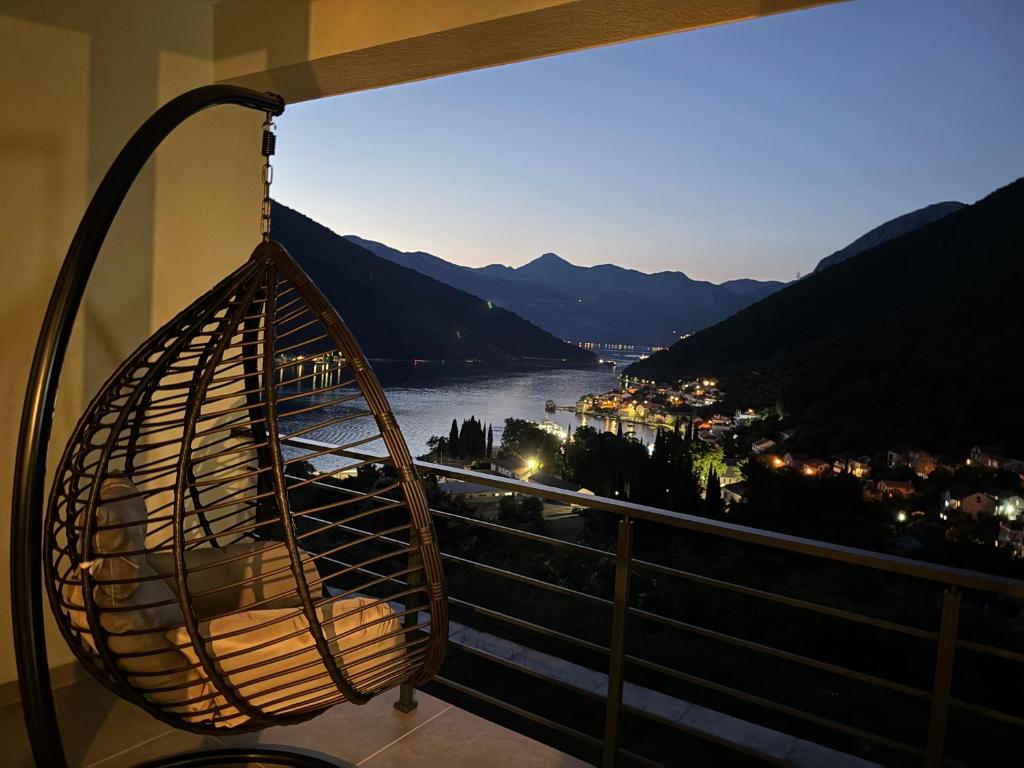 a swing hanging from a balcony with a view of a river at HiL's Bay View Apartments in Tivat