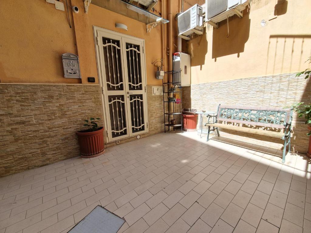 une cour vide avec une porte et un banc dans l'établissement Aurora's house Materdei, à Naples