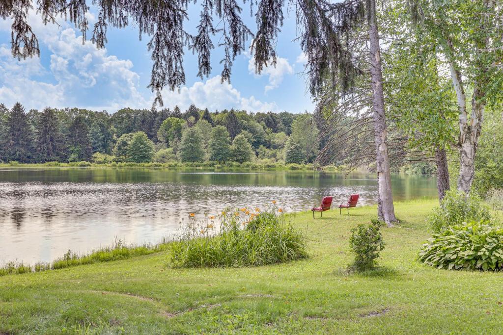 two chairs sitting on the grass near a lake at Private 5-Acre Lake Pet-Friendly Grove City Home in Grove City