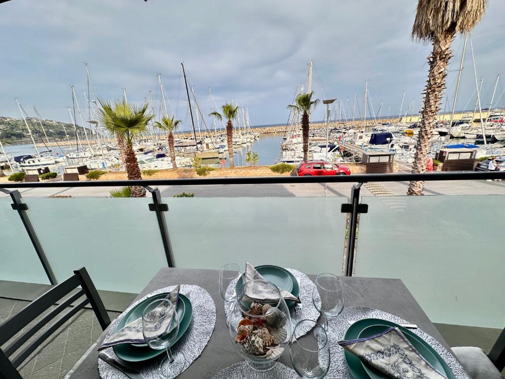 a table with a view of a harbor with boats at Marina dei Sogni - Appartamento fronte mare con terrazza e aria condizionata in San Lorenzo al Mare
