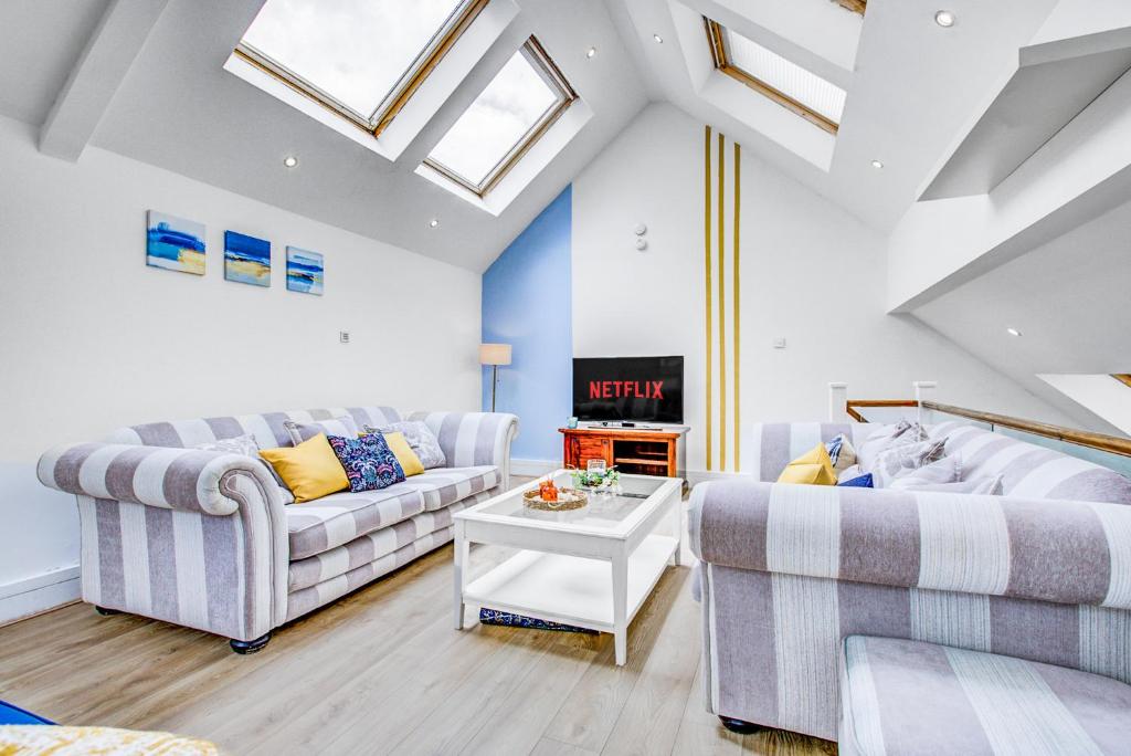 a living room with two couches and a table at Wimbledon 3Bath Sleeps7 AELTC in London