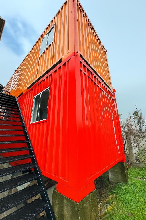 a red house with an orange roof on some stairs at Container 260 in Cambará