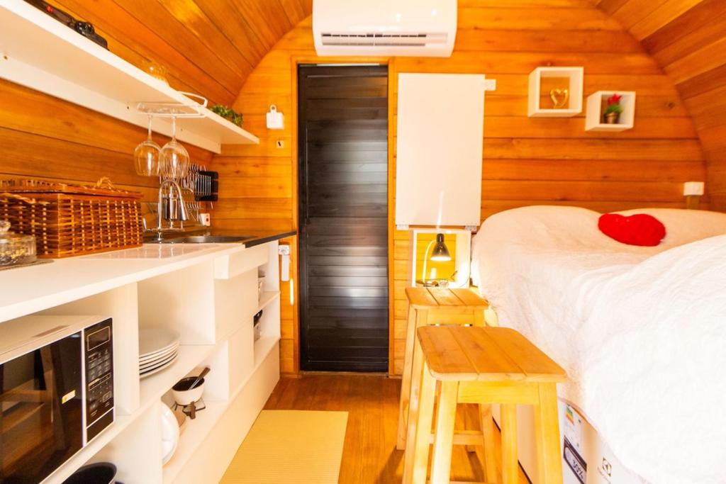 ein Schlafzimmer mit einem Bett in einem Holzzimmer in der Unterkunft Cabana com banheira em formato de barril in Curitiba