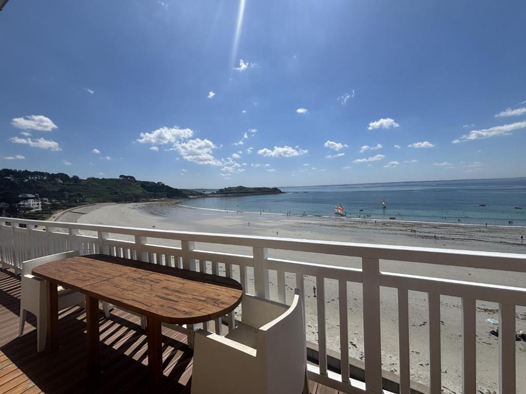 une table sur un balcon avec vue sur la plage dans l'établissement Ile aux moines t3, à Trébeurden