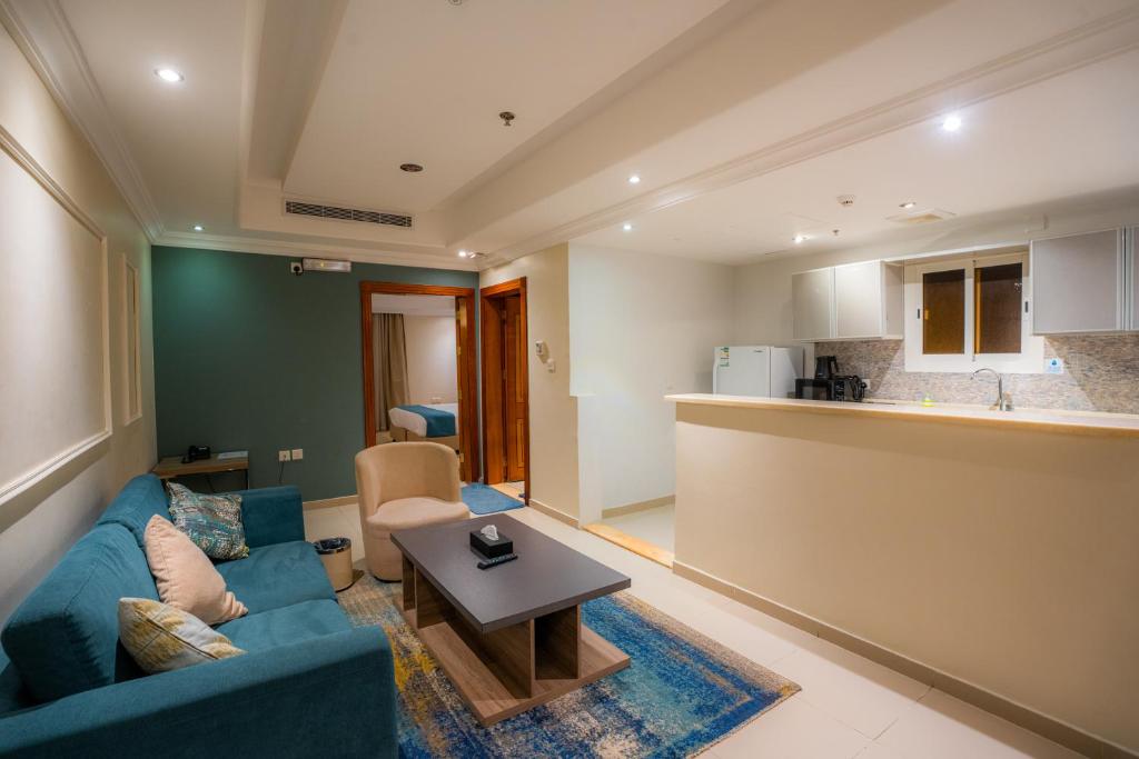 a living room with a blue couch and a kitchen at بيت الضيافة in Jeddah