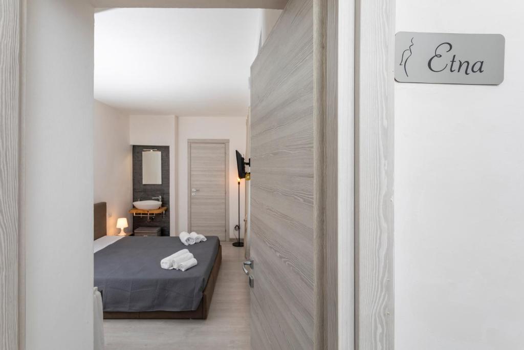 una camera con un letto in una stanza con una porta di Matrangela B&B Catania a Catania