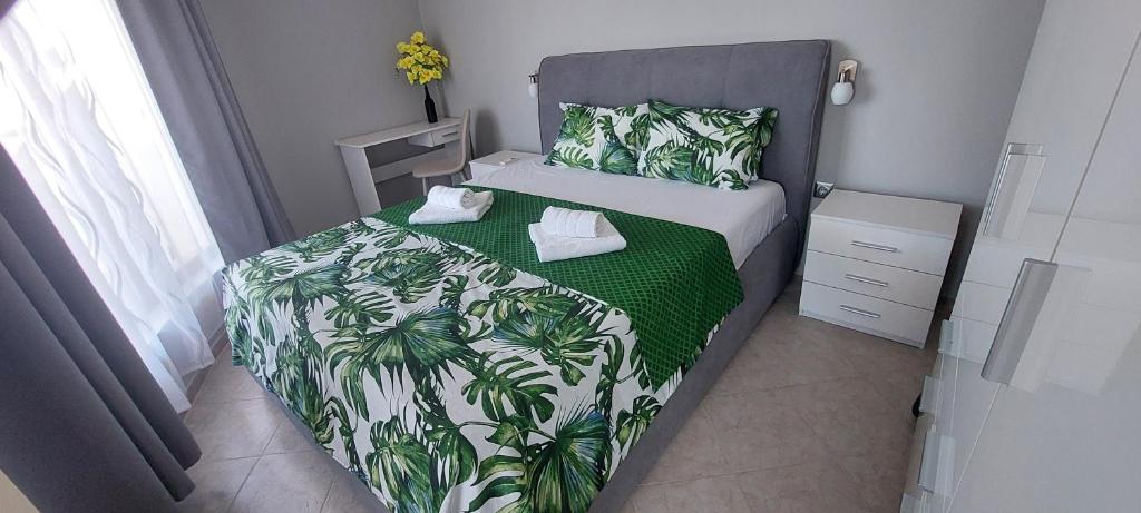 a small bedroom with a bed with a green and white blanket at Ela, Kedar 5 in Sveti Vlas