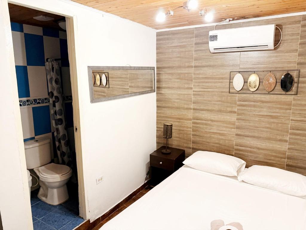 a bedroom with a white bed and a toilet at Casa Mamá Waldy Hostel in Cartagena de Indias