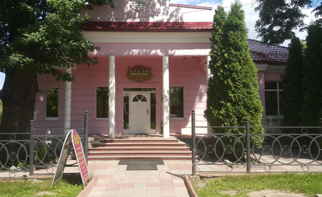 różowy dom z napisem przed nim w obiekcie Hotel Four Crowns w mieście Dmitrow