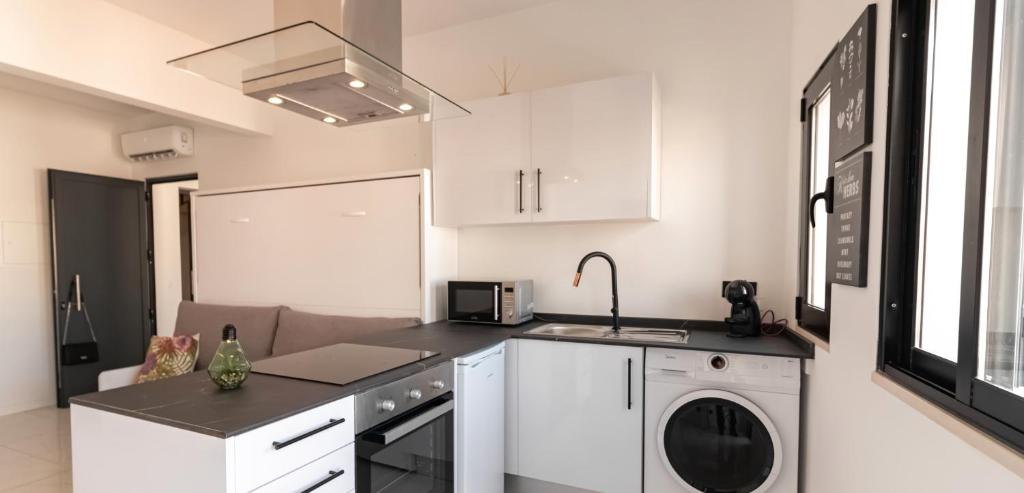 a kitchen with white cabinets and a washer at Mi Casa Es Su Casa Nº3 in Albufeira