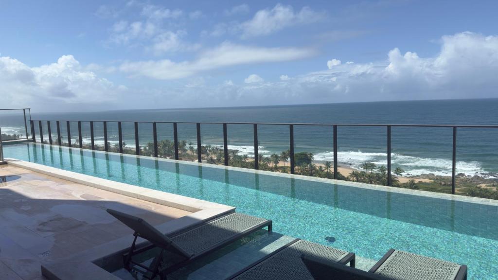 a swimming pool with a view of the ocean at Studio em Salvador- Vista Mar in Salvador
