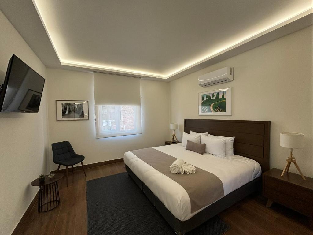 a bedroom with a large bed and a chair at Casa Arcos Chapultepec in Mexico City
