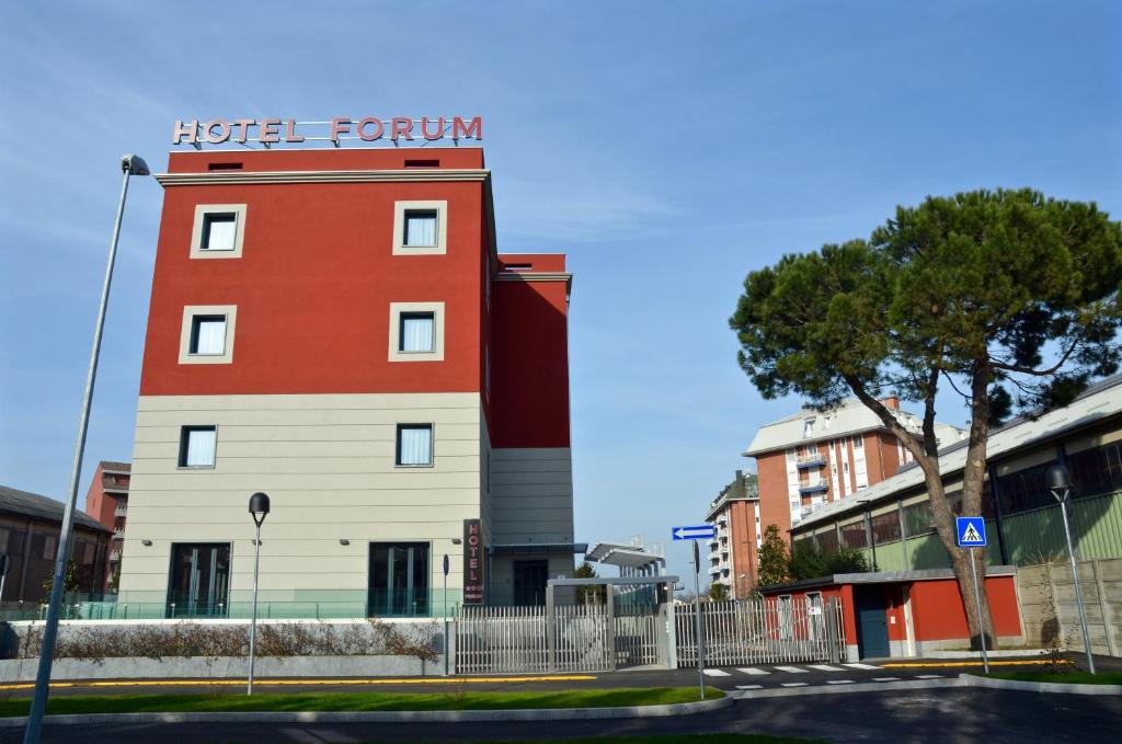 un edificio rosso e bianco con un cartello della camera d'albergo di Hotel Forum a Baranzate