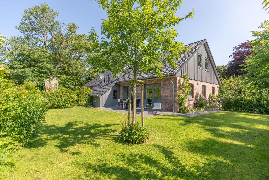 un árbol en el patio de una casa en Ferienhaus Norderreihe, en Ostenfeld