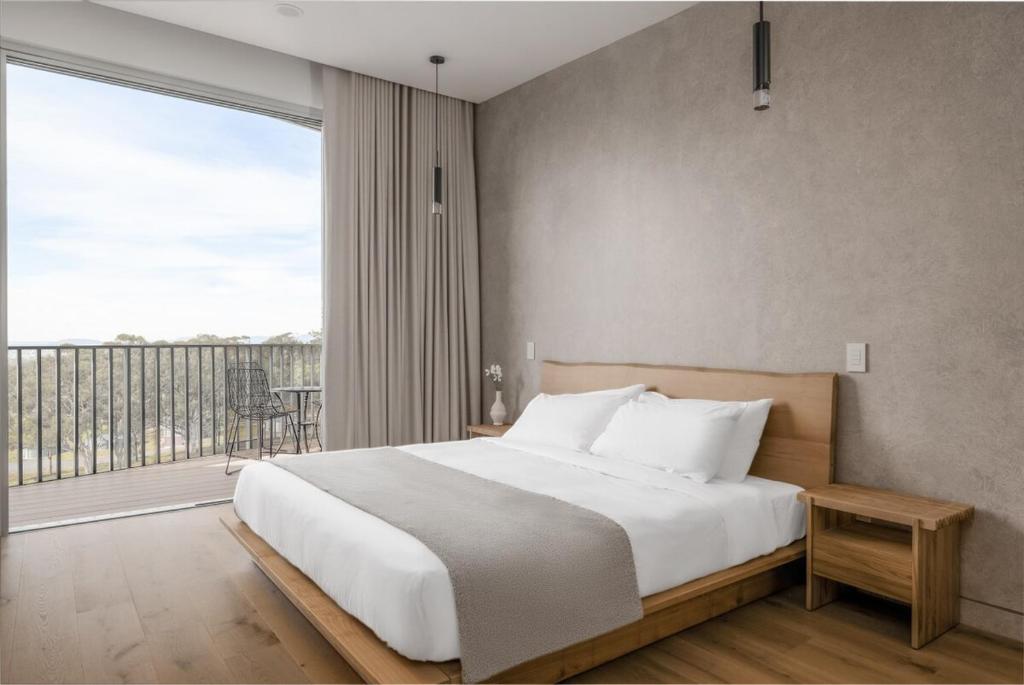 um quarto com uma cama grande e uma janela grande em Mount View Estate One Bedroom Country Stay The Wisteria Escape em Mount View