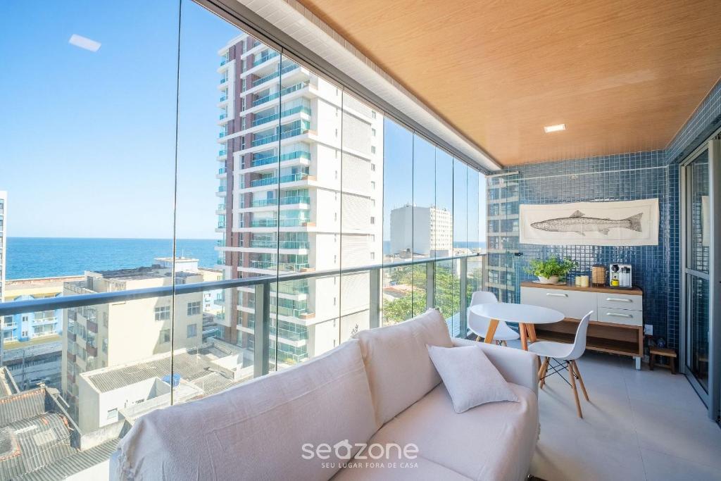 uma sala de estar com um sofá e vista para o oceano em Apartamento a 180m da Praia na Barra OCB0901 em Salvador