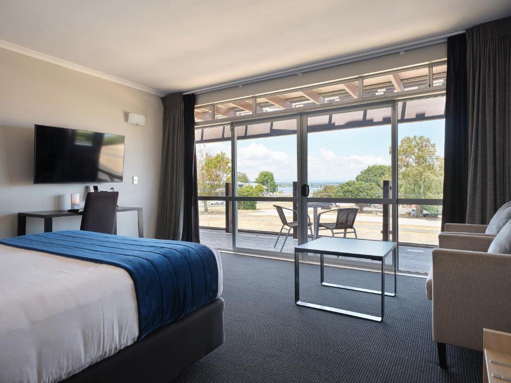 une chambre d'hôtel avec un lit et une grande fenêtre dans l'établissement Suncourt Hotel & Conference Centre, à Taupo