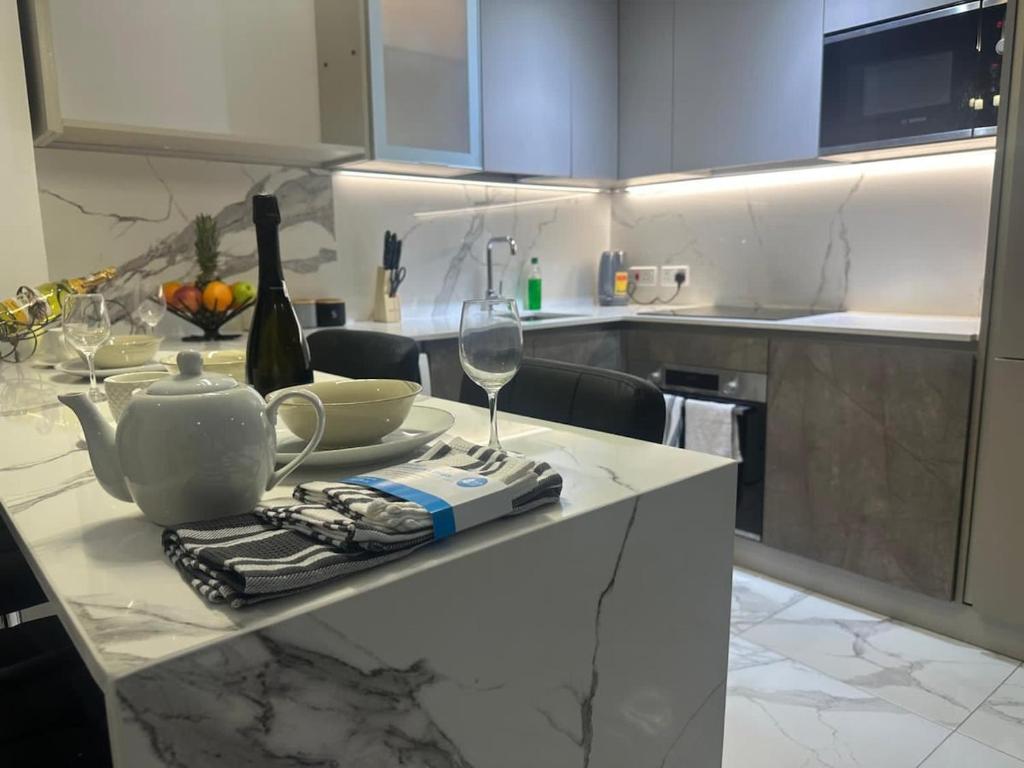 a kitchen with a table with a bottle of wine and glasses at plsa 2bedroom at airport city in Accra
