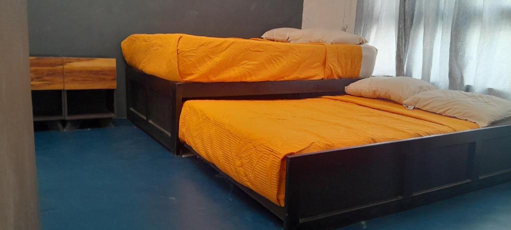 Dos literas con sábanas amarillas en una habitación. en Casas Costa Azul, en Acapulco