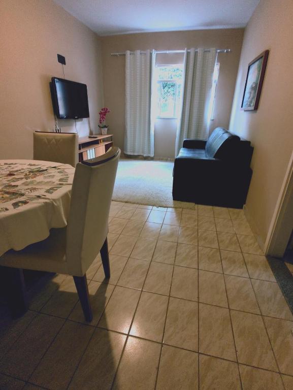 a living room with a table and a couch at Aptos em Duas Barras - RJ in Duas Barras