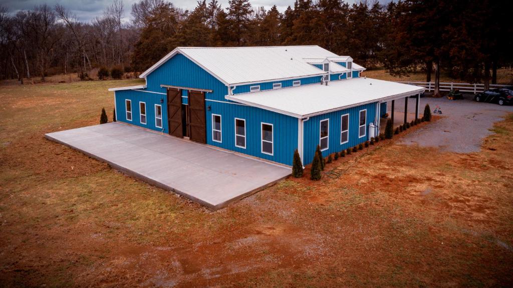 una casa blu con una rampa in un campo di The Blue Barn at the MeadowCreek a Murfreesboro