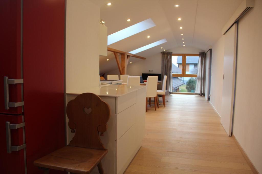 a kitchen with white cabinets and a table and chairs at Appartement Aich-Assach in Aich