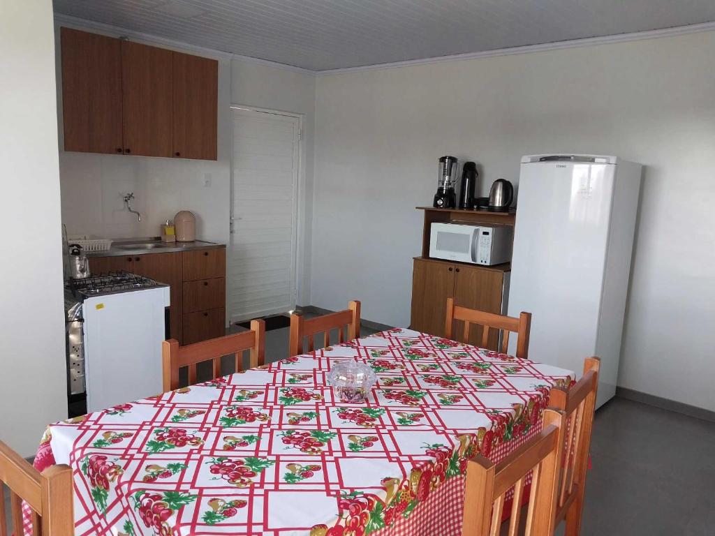 a kitchen with a table with a tablecloth on it at Apartamento Avenida in Ametista do Sul