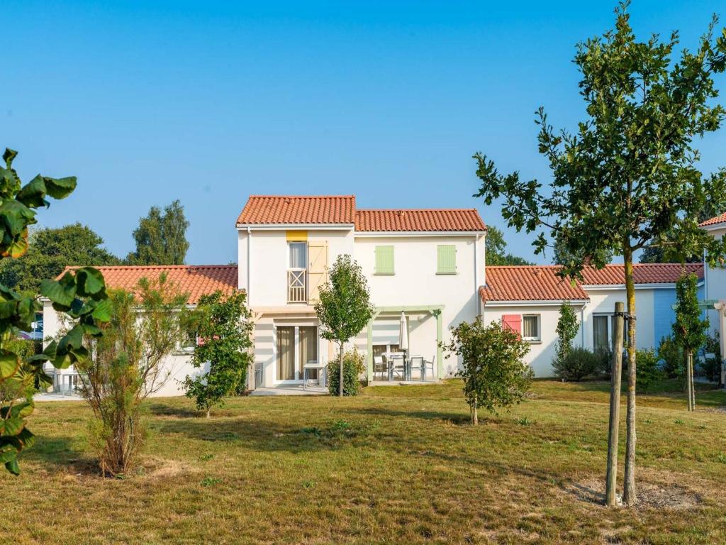 une grande maison blanche avec un toit rouge dans l'établissement Cozy Holiday Home Near Veillon, à Saint-Hilaire-de-Talmont