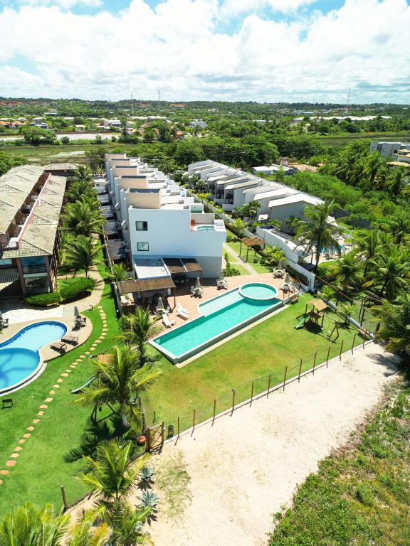 an aerial view of a resort with a swimming pool at Casa Turquesa Pé na areia Piscina infinita Pet friendly Condomínio fechado in Itacimirim
