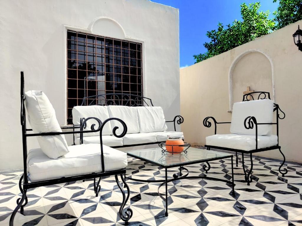 a patio with two chairs and a coffee table at Casa Bugambilia Villa with Private Pool and Parking Merida in Mérida