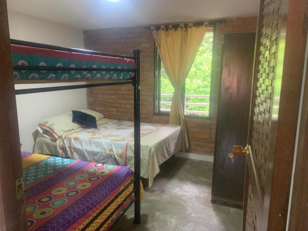a bedroom with two bunk beds and a window at Casa LUCY in Yumbo