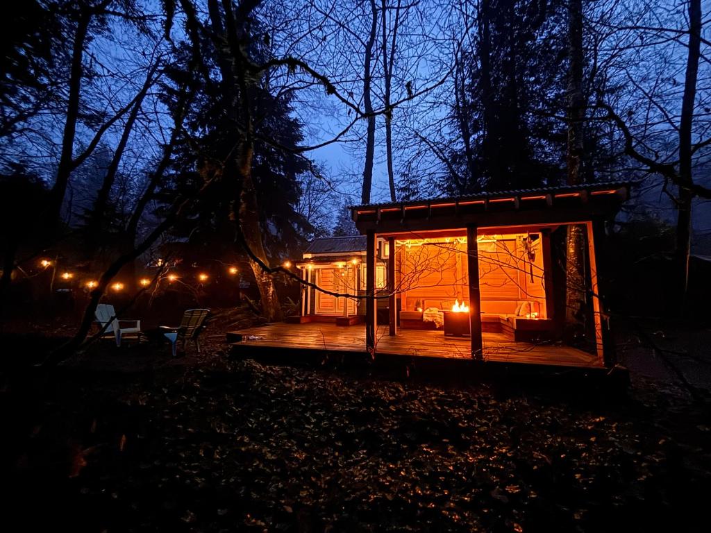 a tiny house in the woods at night at Riverwood Retreat-hot tub and cedar sauna on the river in Squamish