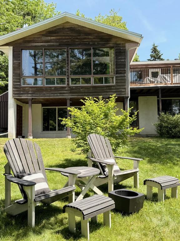 two chairs and a picnic table in front of a house at Bungalow on Lake Charles Halifax-Dartmouth HRM in Bills Island