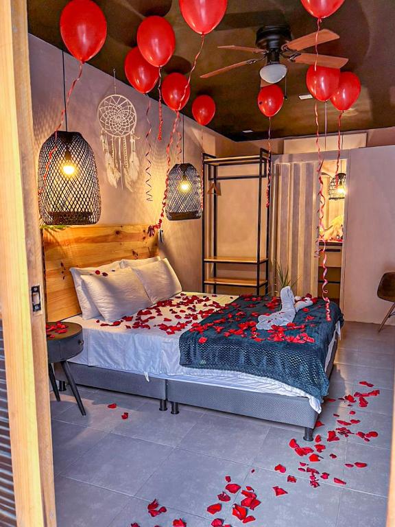 a bedroom with a bed with red balloons on the ceiling at Hotel Casa de Hadas in Minca