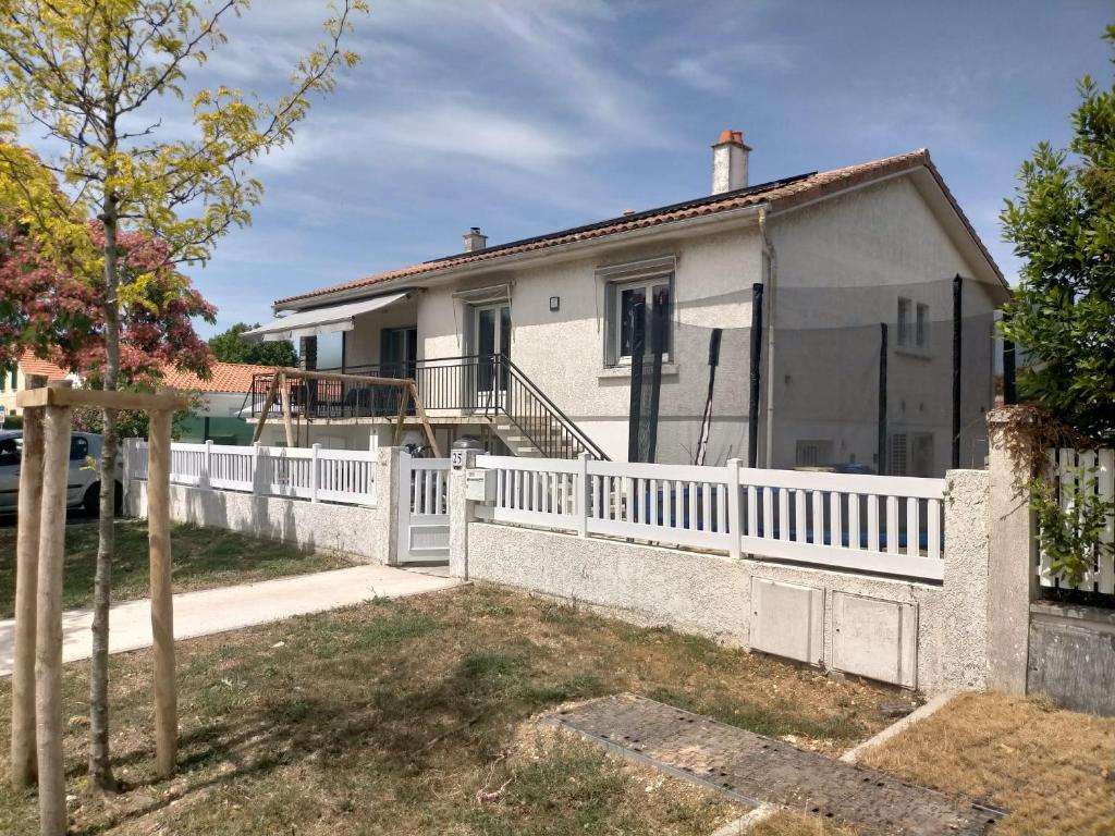 a white fence in front of a house at Maison familiale 4 chambres, proche commerces et plage in Châtelaillon-Plage