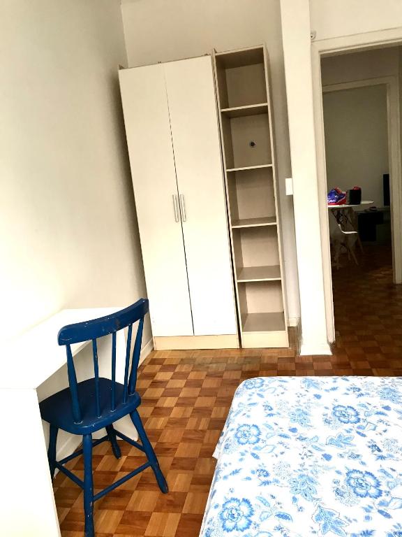 einen blauen Stuhl an einem Schreibtisch in einem Schlafzimmer in der Unterkunft Ap Demetrio Ribeiro in Água Boa