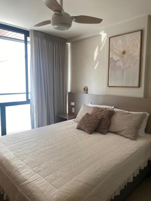 ein Schlafzimmer mit einem großen weißen Bett mit Deckenventilator in der Unterkunft Apto novo perto da UFF e Plaza in Niterói