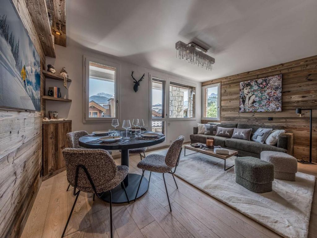 ein Wohnzimmer mit einer Couch und einem Tisch und Stühlen in der Unterkunft Courchevel 1850 - Appartement 4 pers - Skis aux pieds avec Parking et Wifi - FR-1-631-232 in Courchevel