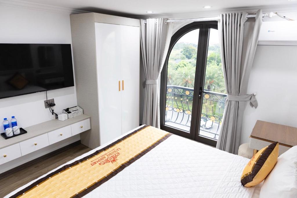 a bedroom with a large bed and a large window at Luxury Airport Hotel in Sóc Sơn