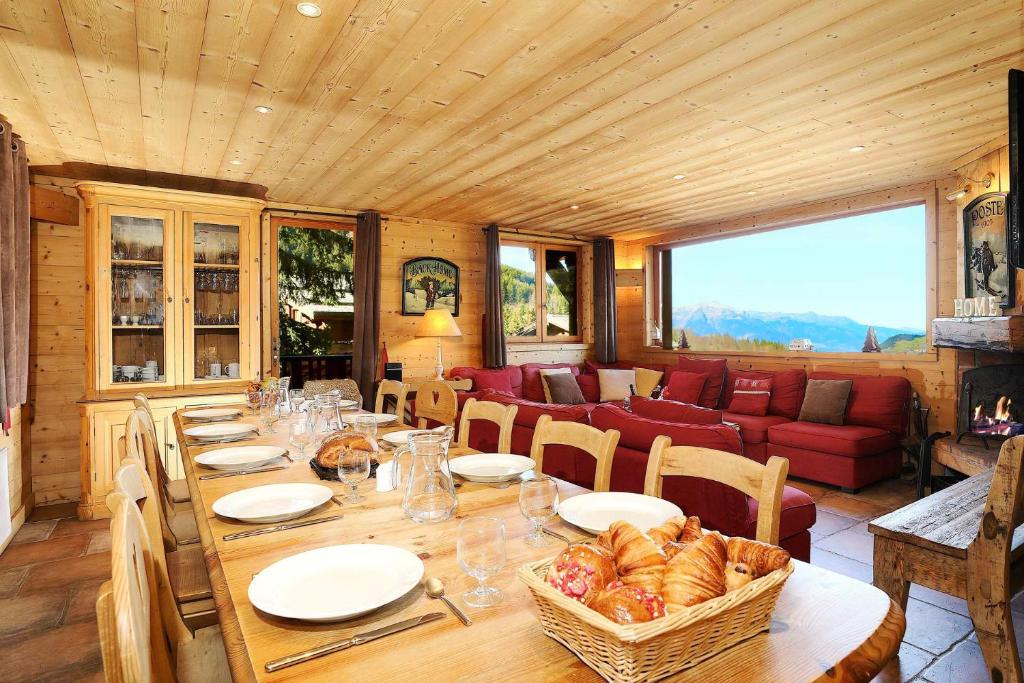 une salle à manger avec une table et un canapé dans l'établissement Charming chalet 8 en suite bedrooms, à La Tania