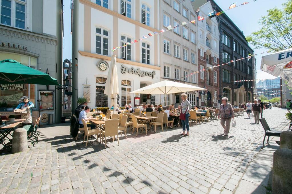 a group of people sitting at tables on a street at Appartements in der historischen Deichstrasse contactless Check in in Hamburg