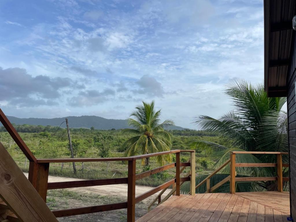 a wooden deck with a view of a field at K S G Cabanas in Dangriga
