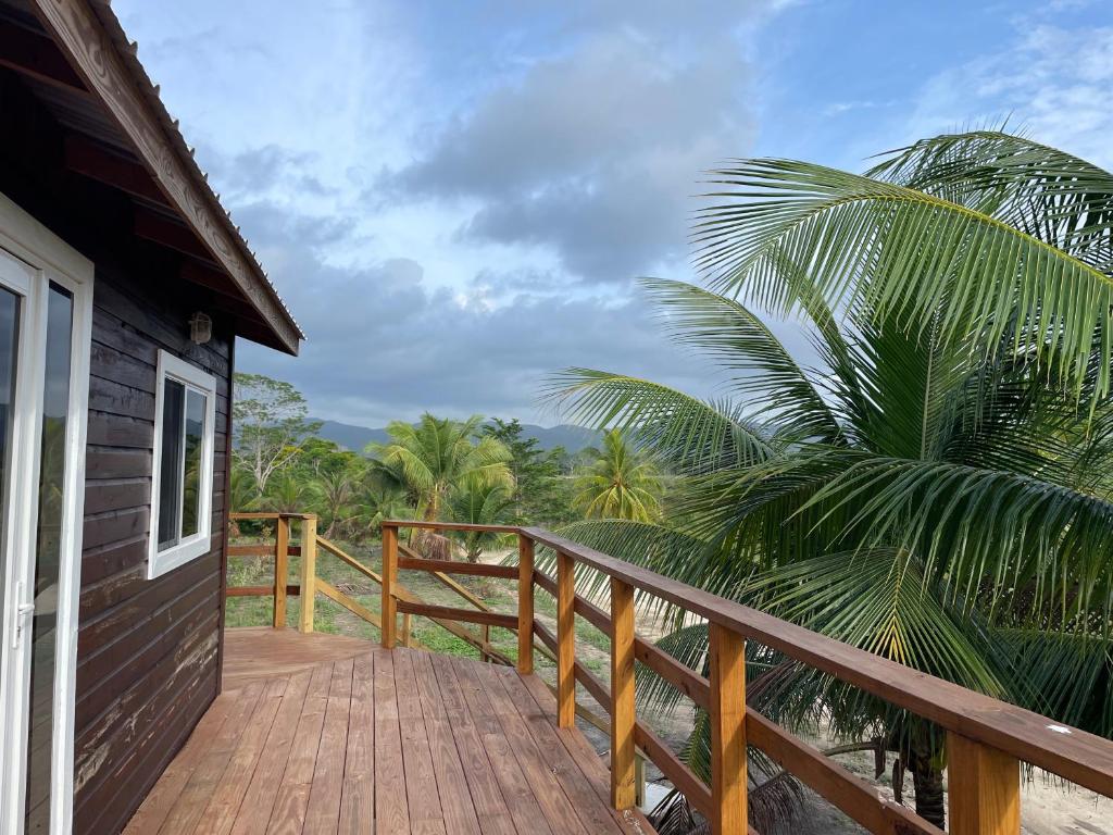 uma passagem de madeira que leva a uma varanda de uma casa em K S G Cabanas em Dangriga