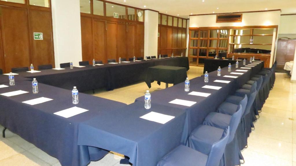 A conference room arranged in a U-shaped layout with bottled water and writing materials.