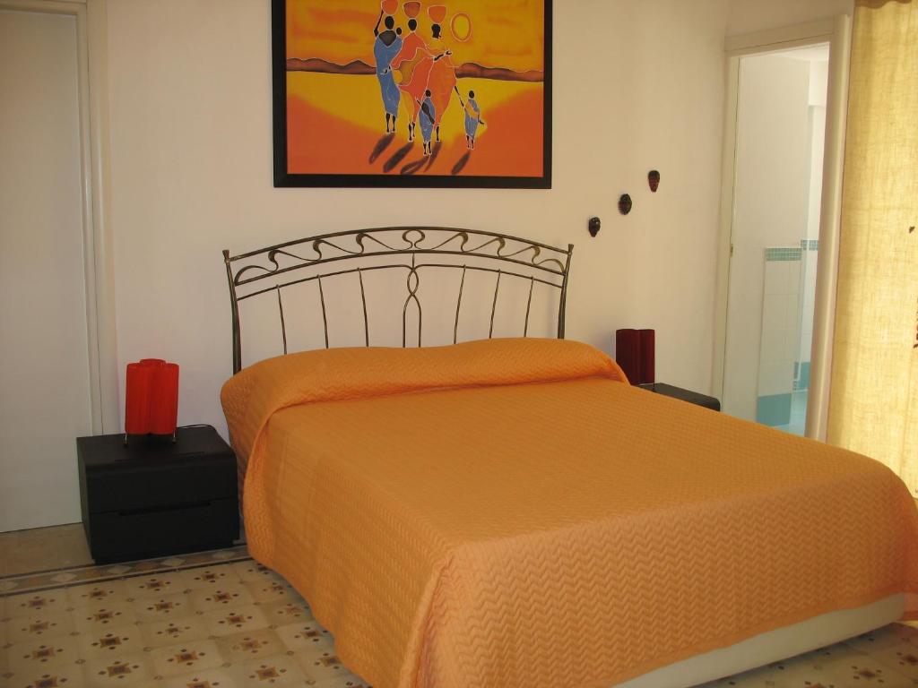 ポンツァにあるLa Casa del Relaxのベッドルーム1室(オレンジ色のベッドカバー付)
