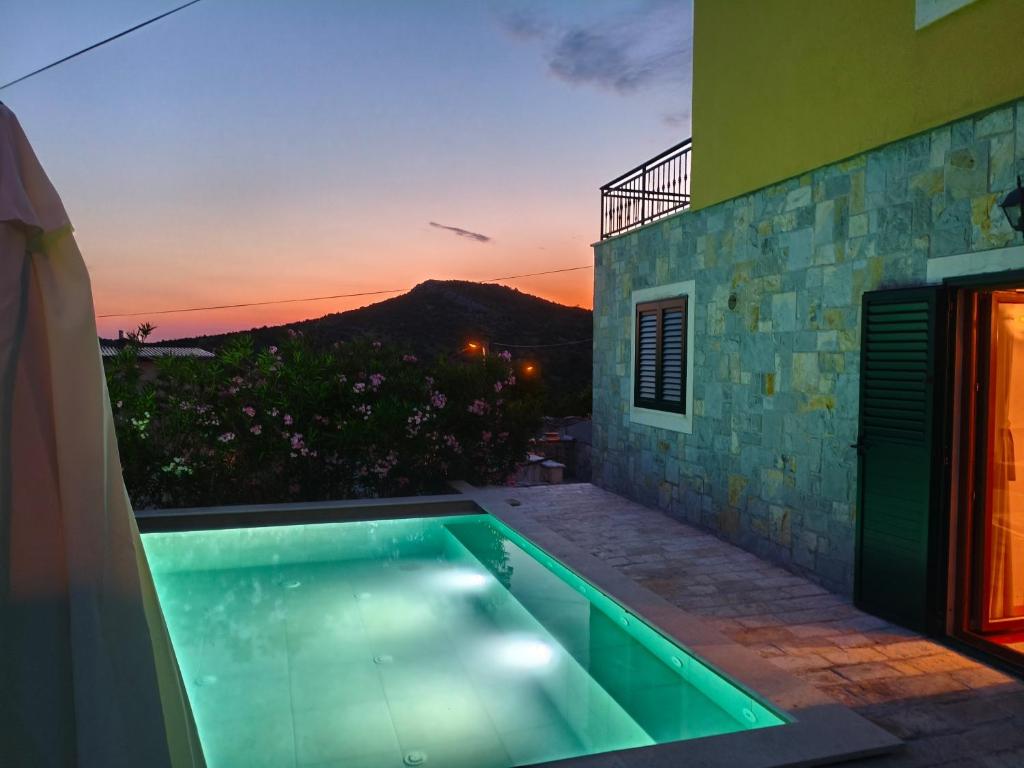 een villa met een zwembad met een zonsondergang bij Villa Mirta in Široke