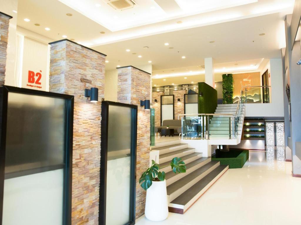 a lobby of a building with a staircase and a building at B2 Hat Yai Rat Uthit Boutique & Budget Hotel in Sathani Hat Yai