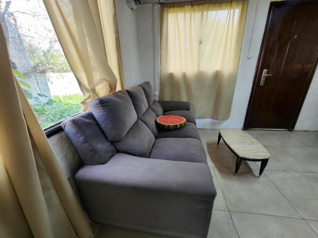 a couch in a living room with a window at Escapada ideal privada y cerca del Rio Con todo in Aguas Corrientes